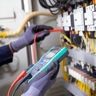 Close up of gloved hands running electrical safety test