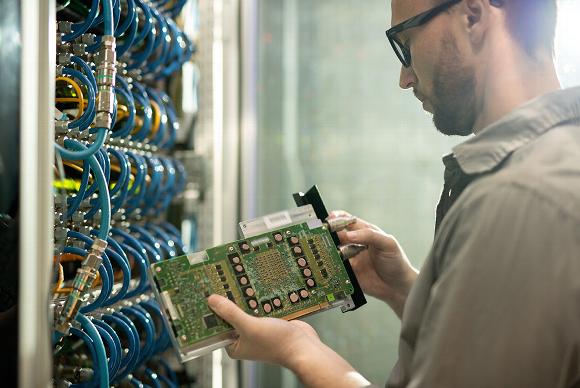 Man repairing motherboard for network data centre